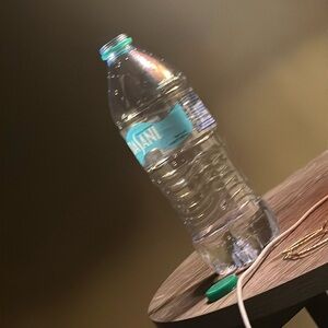 A sleek, clear Dasani water bottle with a blue cap, perfect for repurposing.